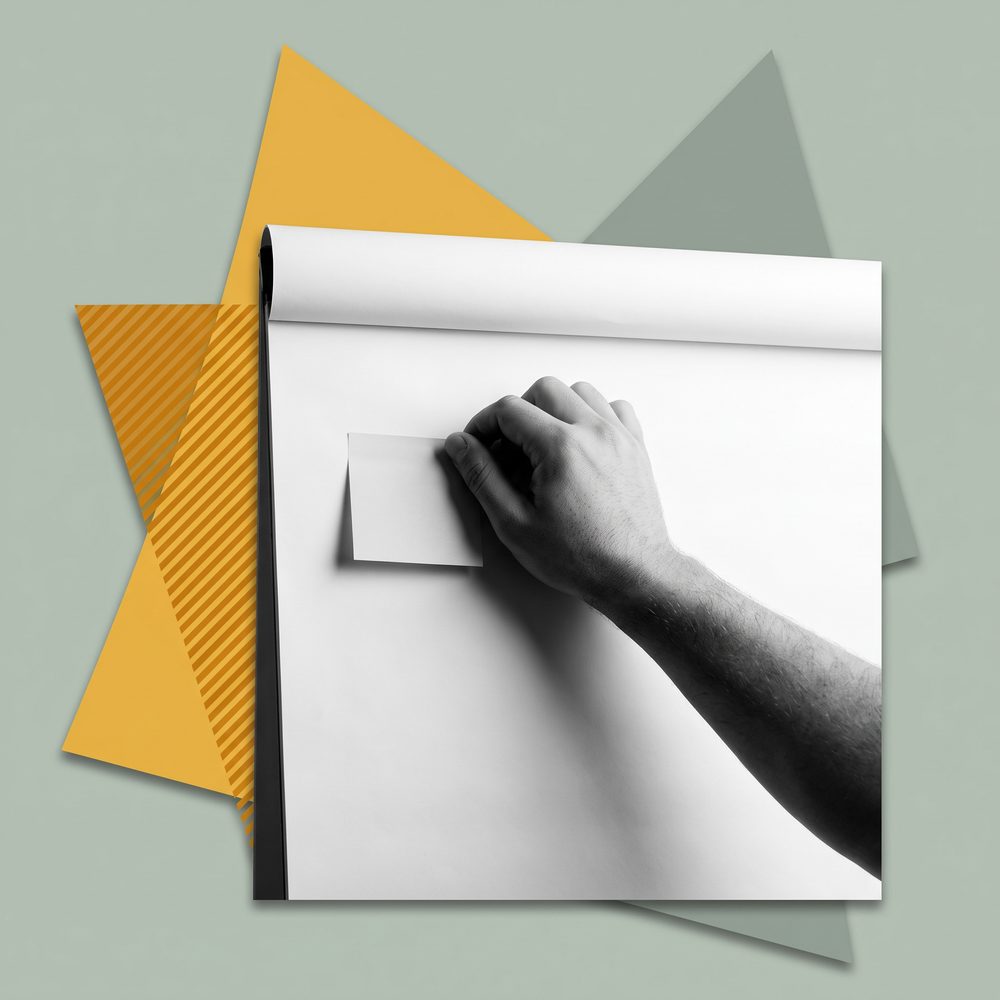 Eine Hand setzt einen Klebezettel auf einen Flipchart-Bogen
